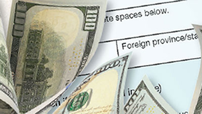 A tax form with $100 dollar bills to the left. The tax form reads see instructions, spaces below and foreign province.