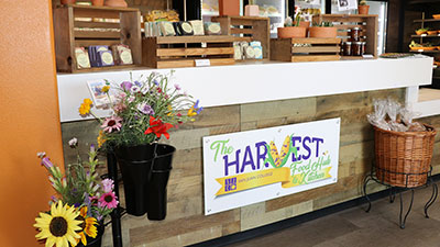 The front counter of the Harvest Food Hub with fresh flowers, artisans soaps on the counter.