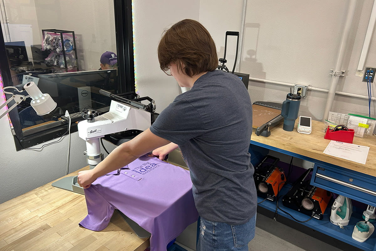 SJC students using equipment to print on a t-shirt  in The Big Idea Makerspace on San Juan College campus