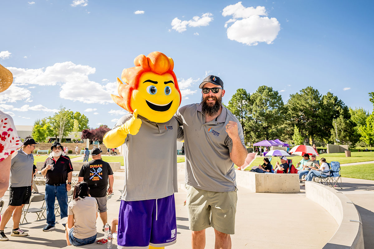 Blaze standing with an individual giving a thumbs up at the Sumertime Family Fun Festival