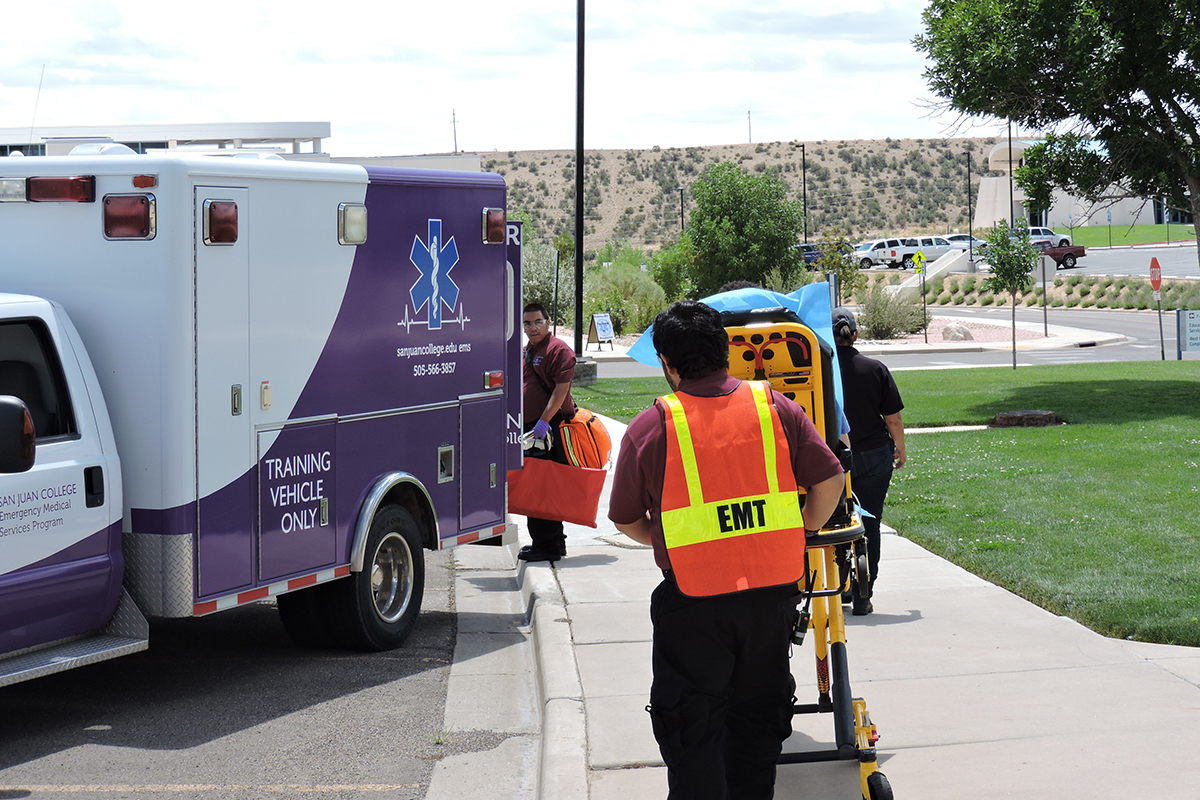 EMS students prepare gurney and program Ambulance for a classroom
